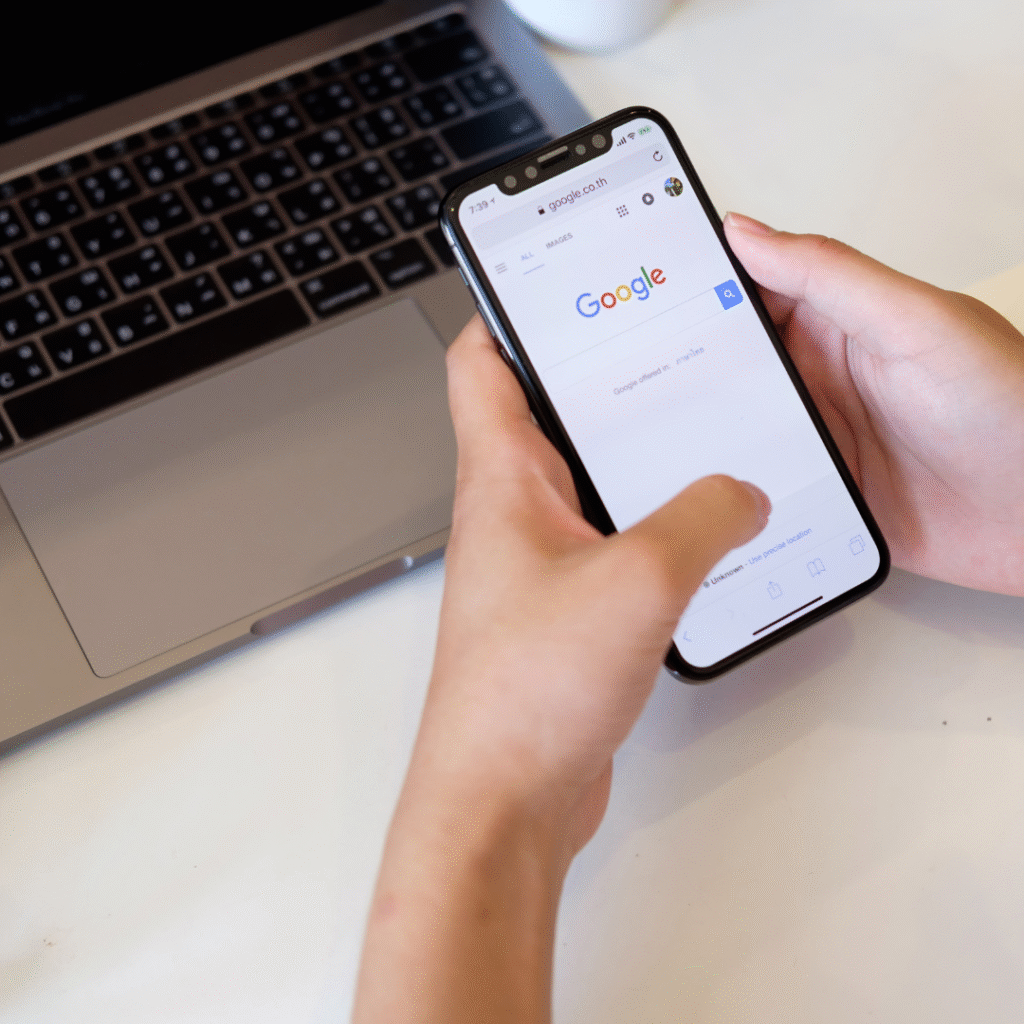 Blog_zoekvolumevsintertievolume_3 Laptop en telefoon in beeld, waarbij op de telefoon Google open staat