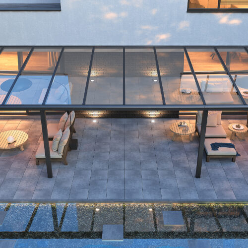 Moderne aluminium terrasoverkapping met glazen dak en luxe loungeset bij een strakke woning, geschikt voor outdoor living.