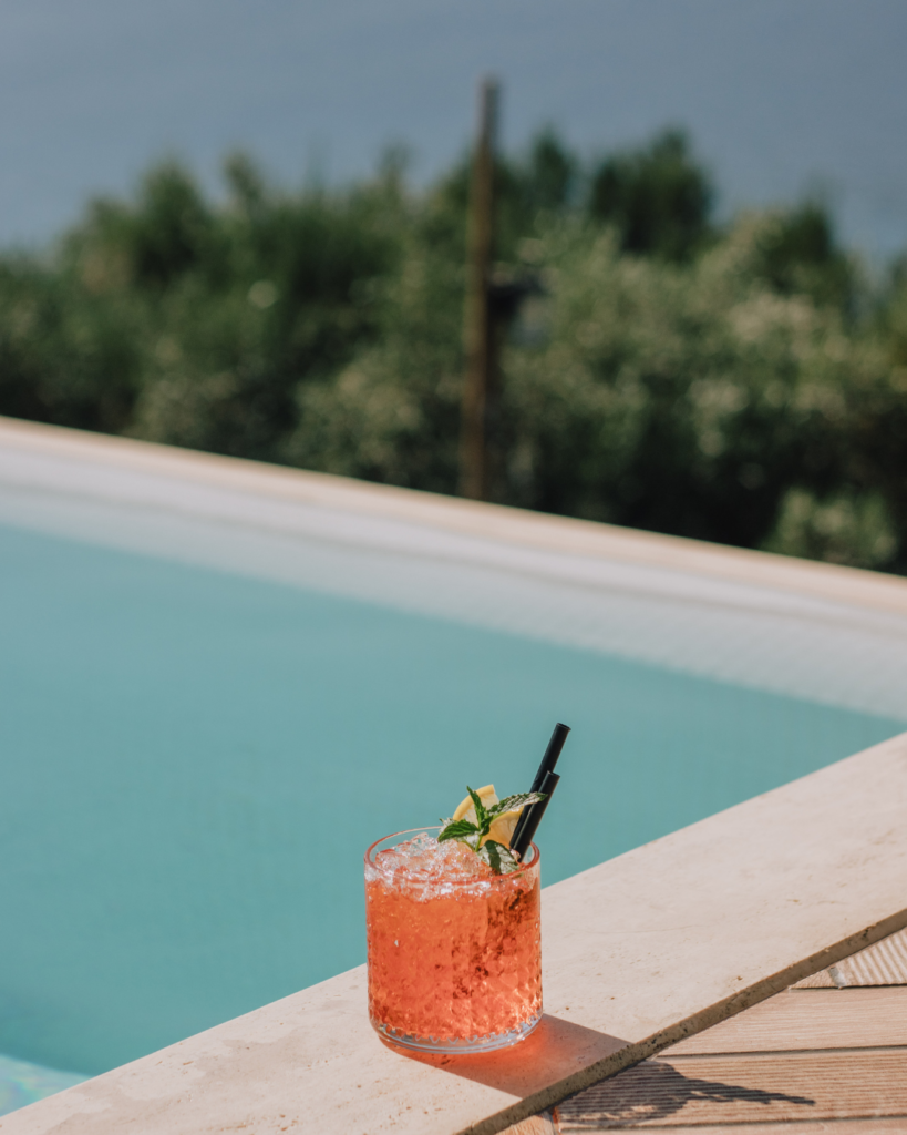 Cocktail aan de rand van het zwembad Cocktail staat op de rand van het zwembad