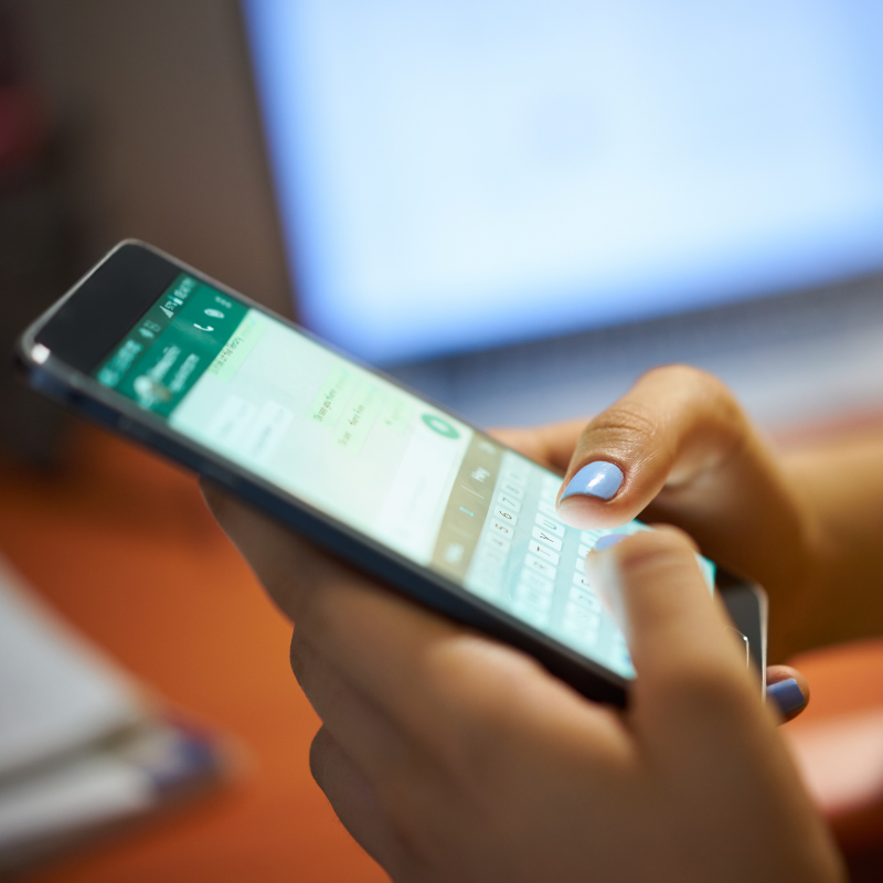 Vrouw typt bericht op Whatsapp Vrouw typt bericht op WhatsApp op haar smartphone